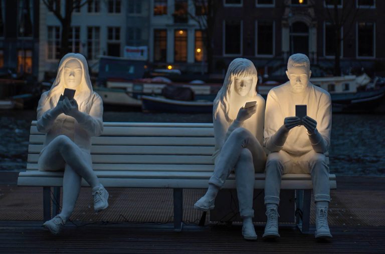 Mobiltelefonnal megvilágított szobrok tükrözik a szomorú valóságot
